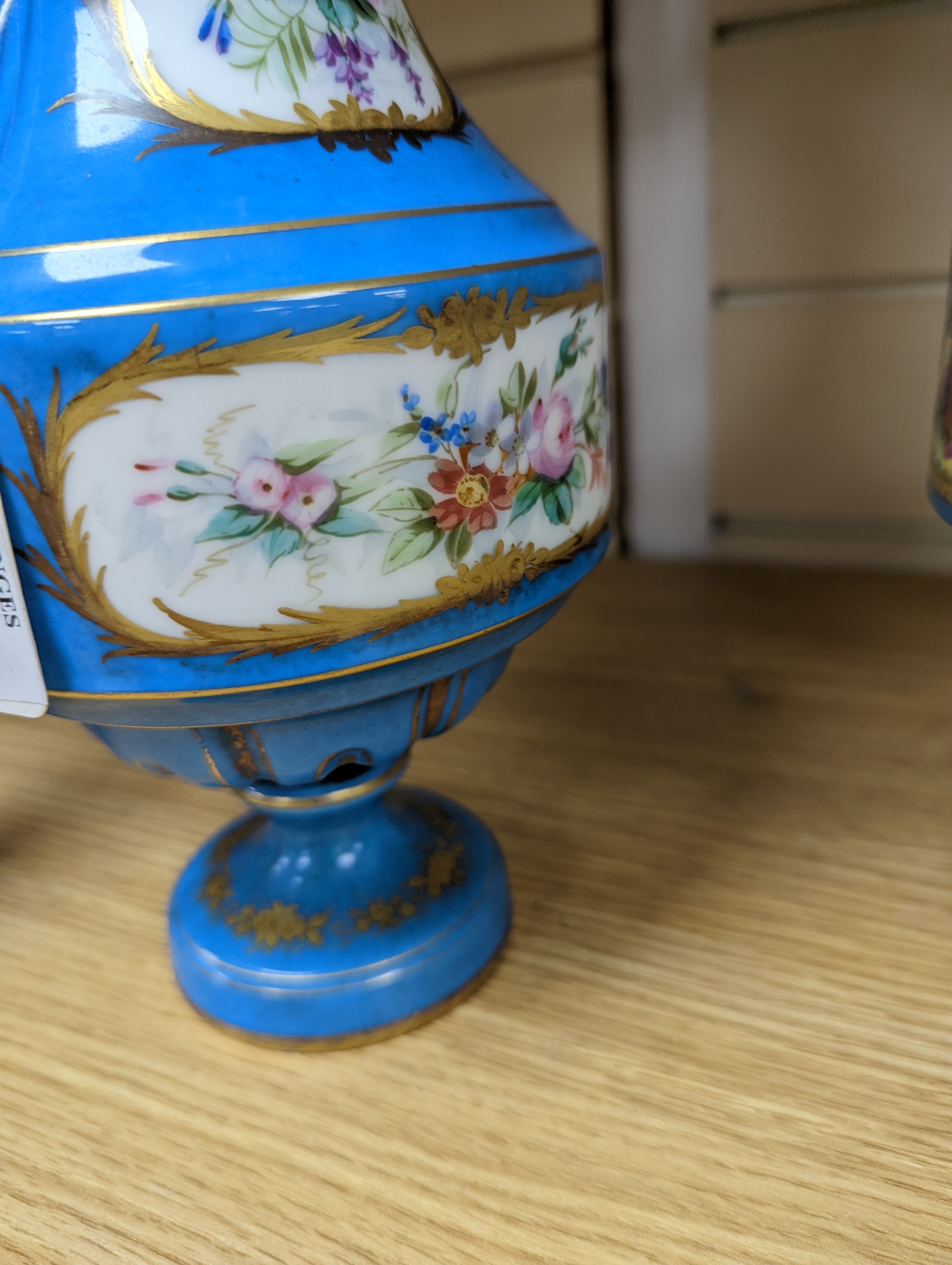 A pair of Sevres style porcelain bleu celeste ground vases and covers, 34cm